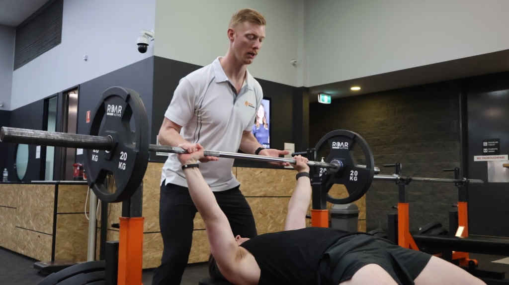 Physiotherapist spotting a bench press