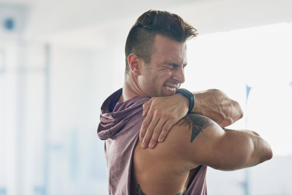 Man clutching his shoulder with pain