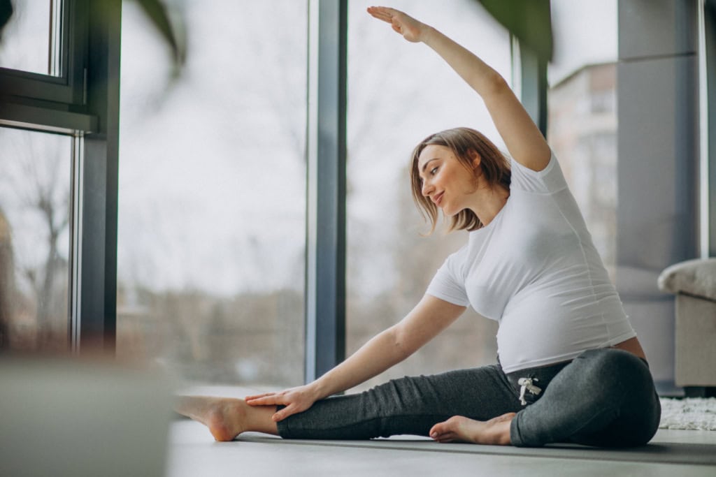 Pregnant woman doing yoga stretch
